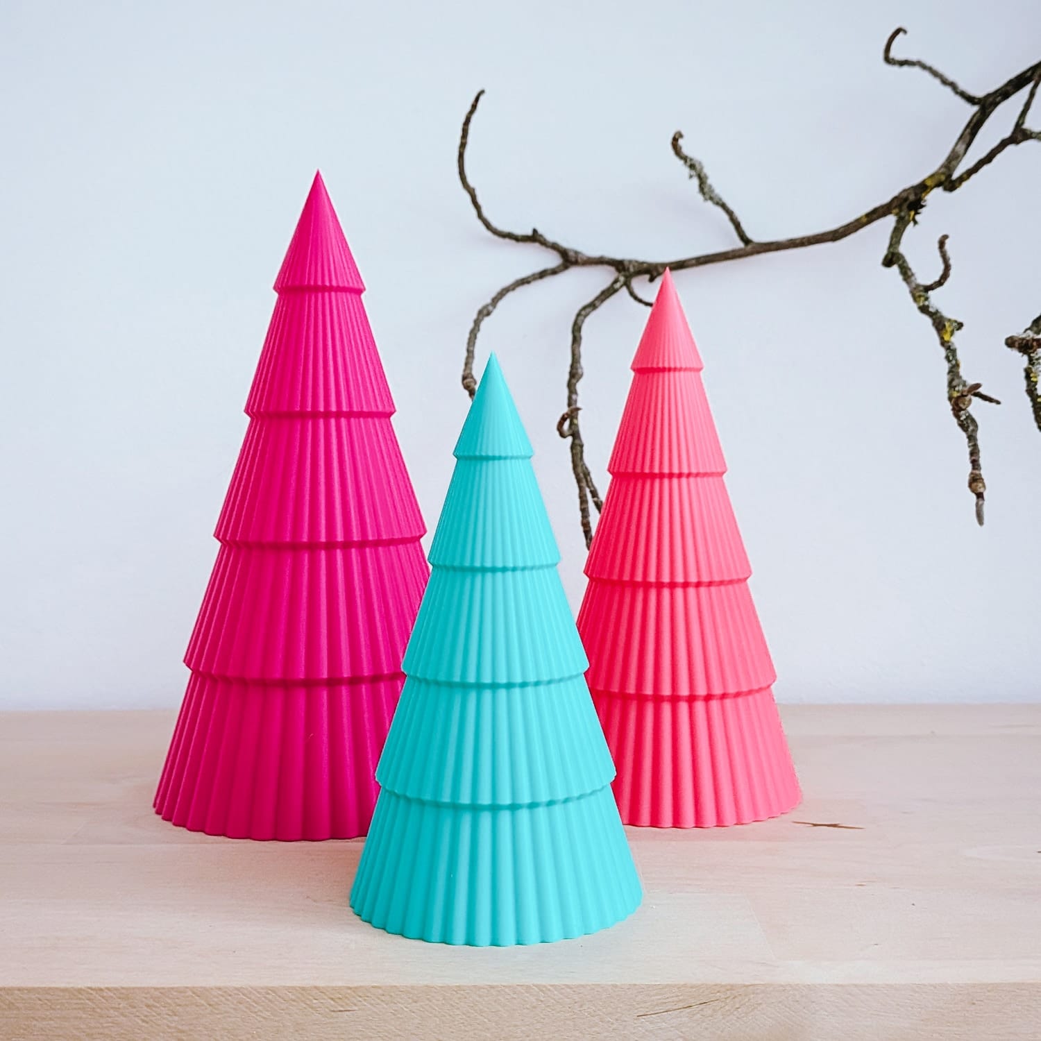 Mini-Weihnachtsbäume in Pink, Türkis und Koralle nebeneinander