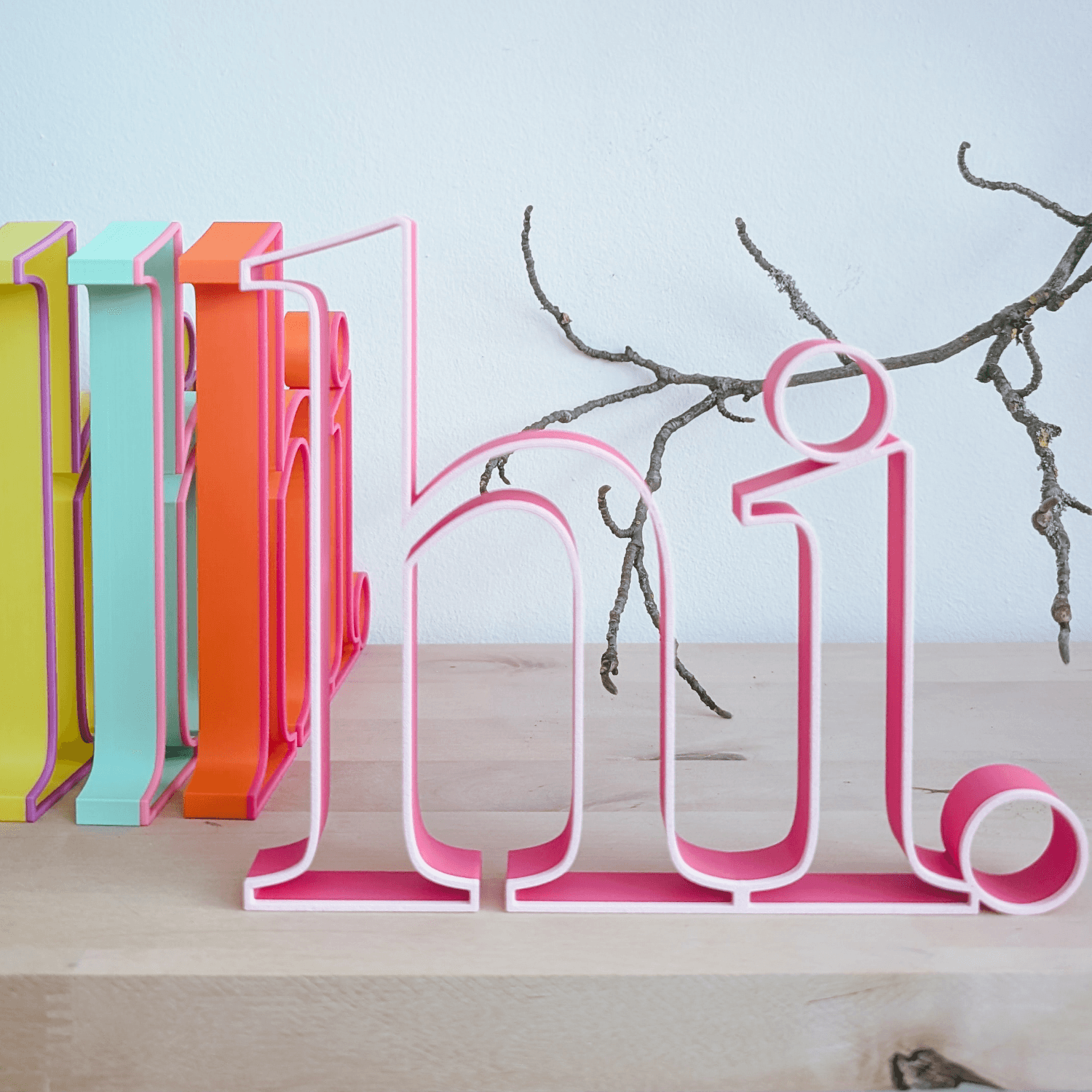 Schriftzug „hi.“ in Rosa vor weiteren bunten Schriftzügen